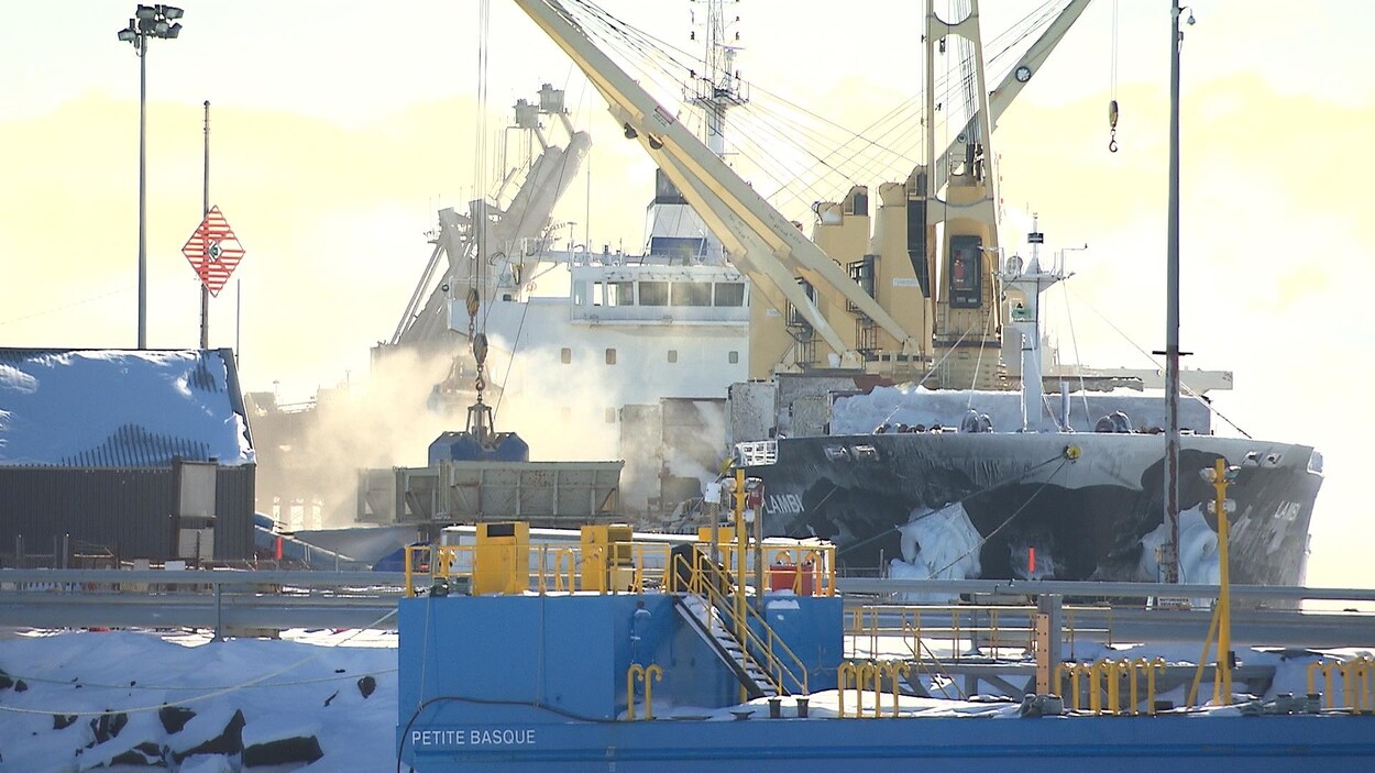 De la brume émane d'un bateau-cargo accosté au quai de Sept-Îles.