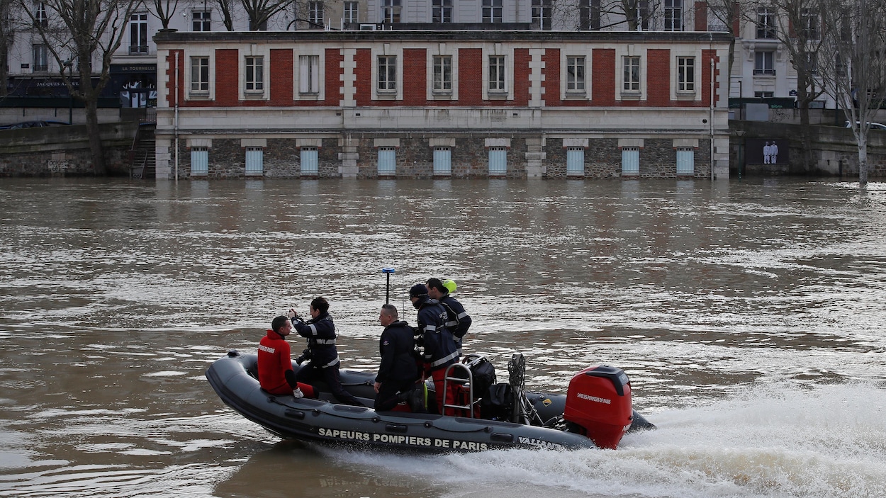 Des pompiers naviguent sur la Seine. Des pompiers naviguent sur la Seine.