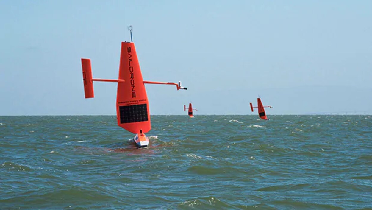Trois petits bateaux rouges sur lesquels est écrit Saildrone.