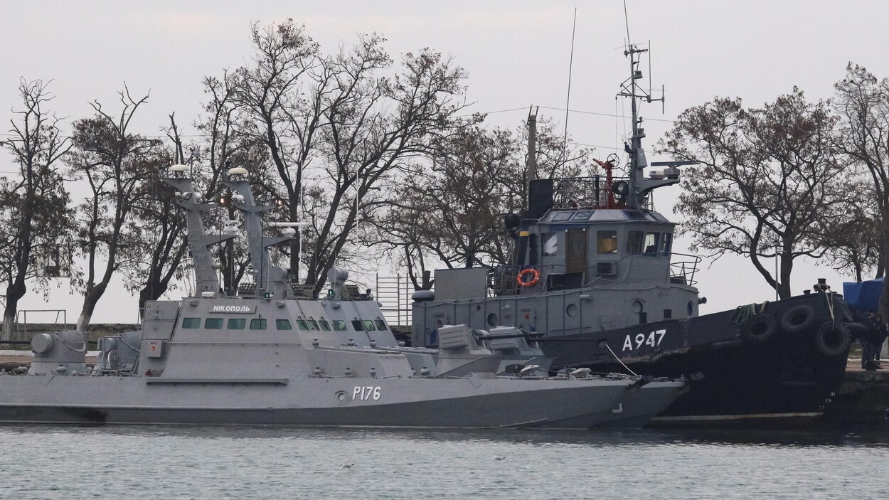 Trois bateaux amarrés au port.