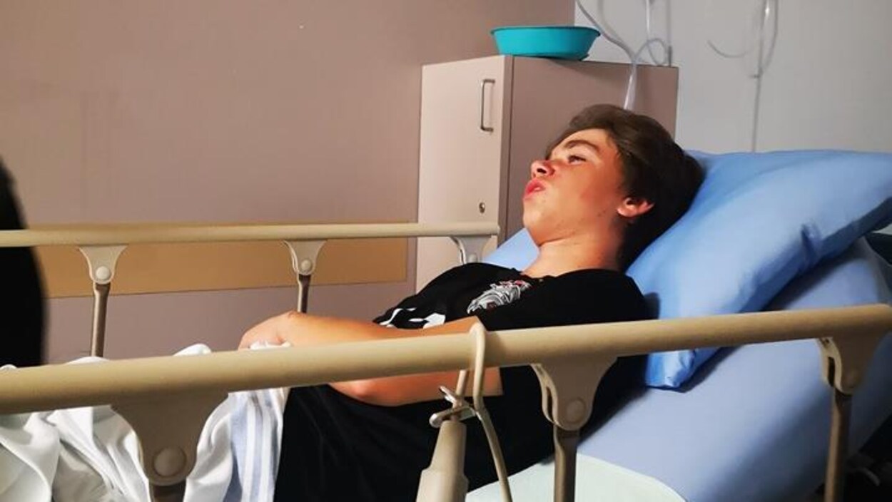 Un jeune homme dans un lit d'hôpital.