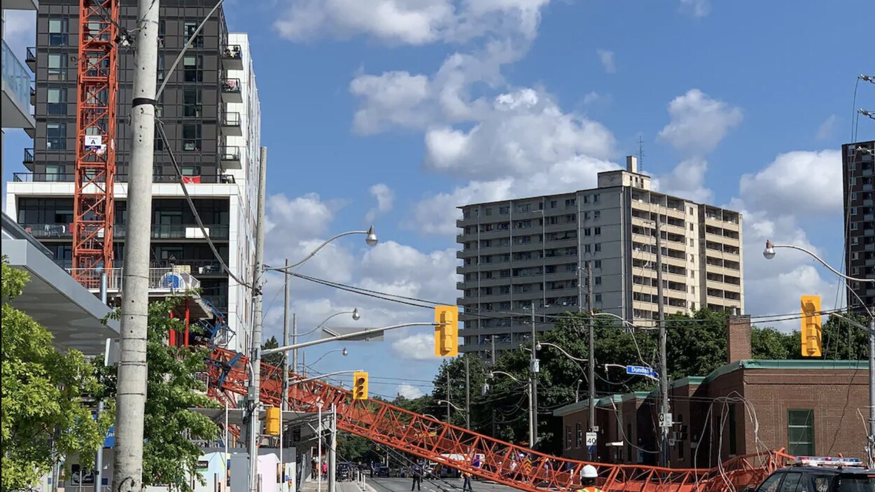 Une grue effondrée au milieu d'une rue du centre-ville de Toronto.