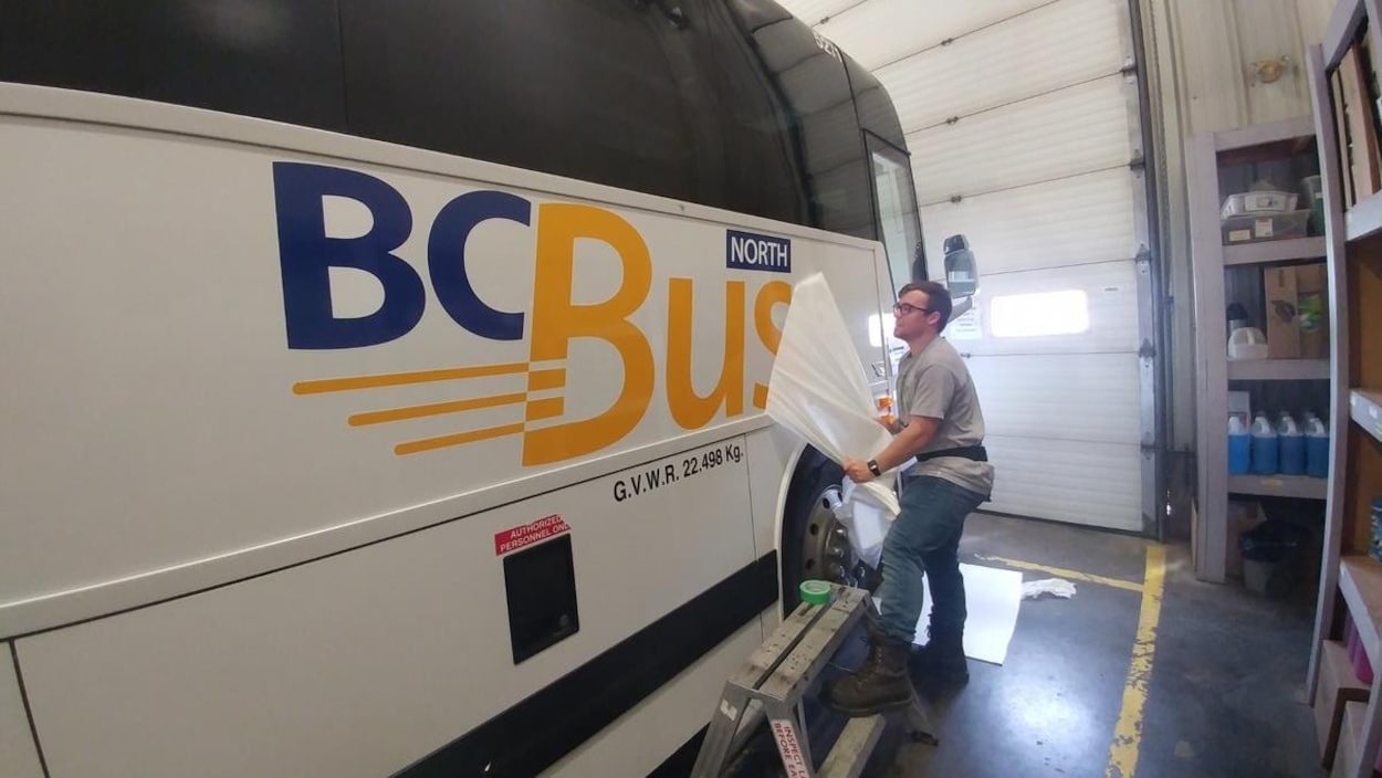 Un bus blanc avec de l'écriture en bleue et jaune. Un bus blanc avec de l'écriture en bleue et jaune.