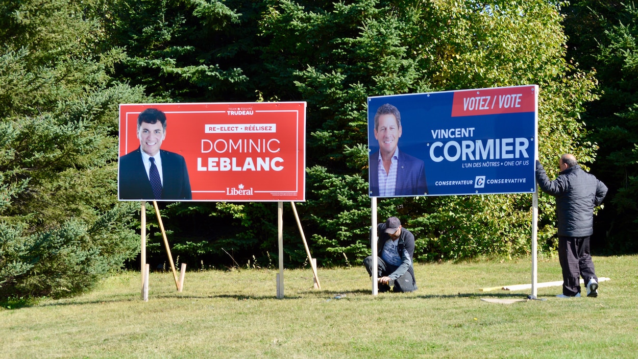 Des affiches des candidats Dominic LeBlanc et Vincent Cormier devant des arbres