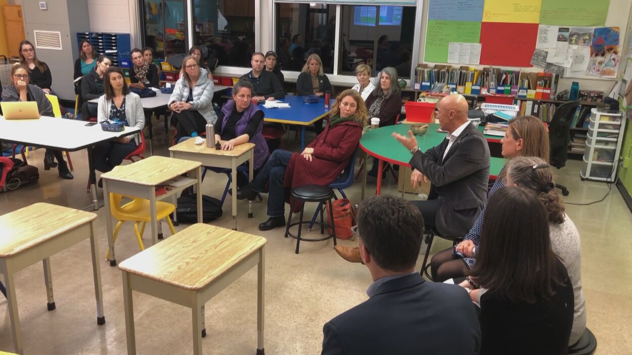 Réunion avec des parents d'élèves dans une salle de classe d'école primaire.