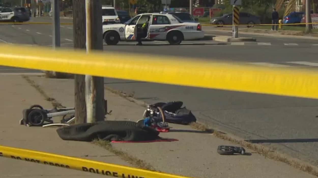 Une poussette et des objets sur le trottoir sur la scène d'un accident de la route.