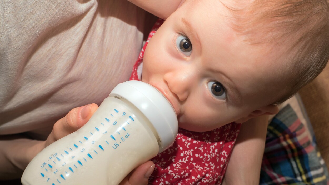 Une mère fait boire un bébé à la bouteille.