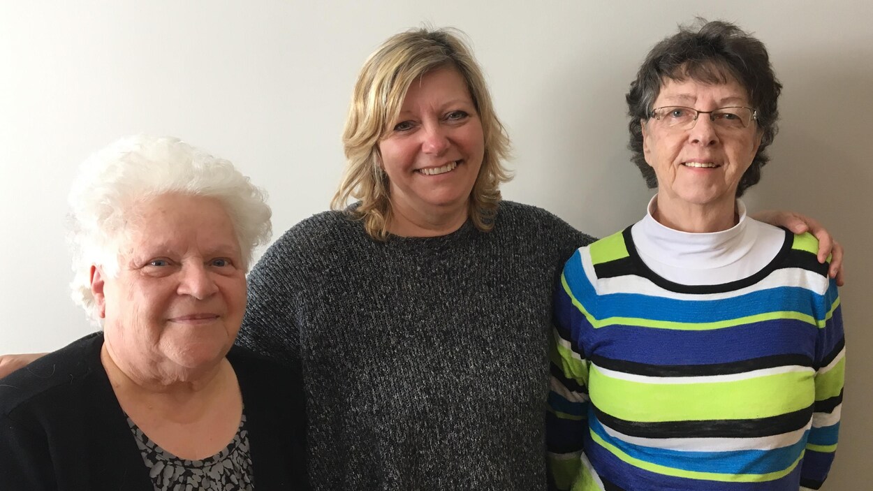 Trois femmes posent pour la caméra.