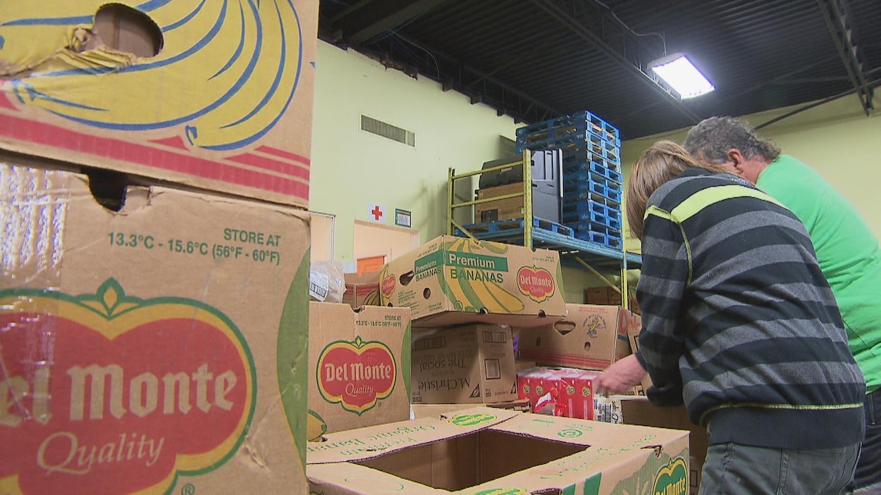 Des bénévoles s'affairent dans un entrepôt d'aide alimentaire.