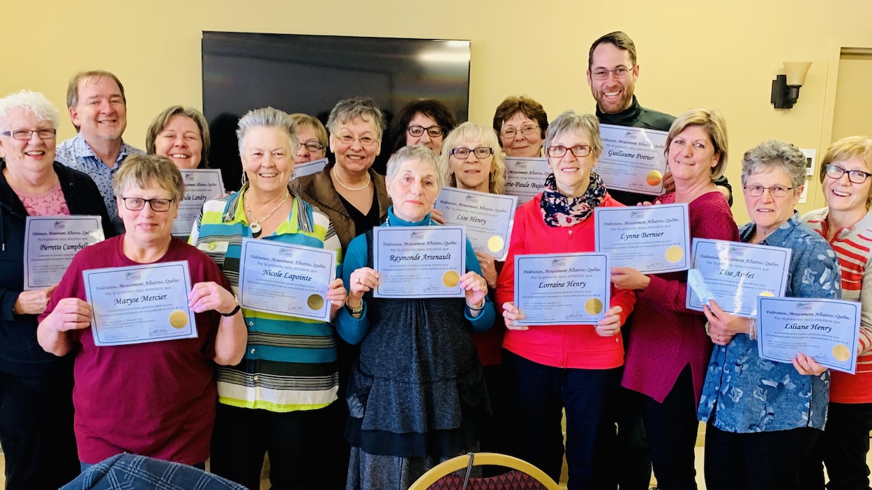 Une dizaine de personnes tiennent un certificat dans leur main, tout sourires.