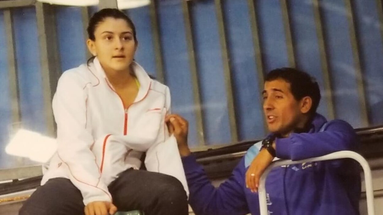 Une jeune fille assise sur une chaise qui écoute un homme en train de lui parler.