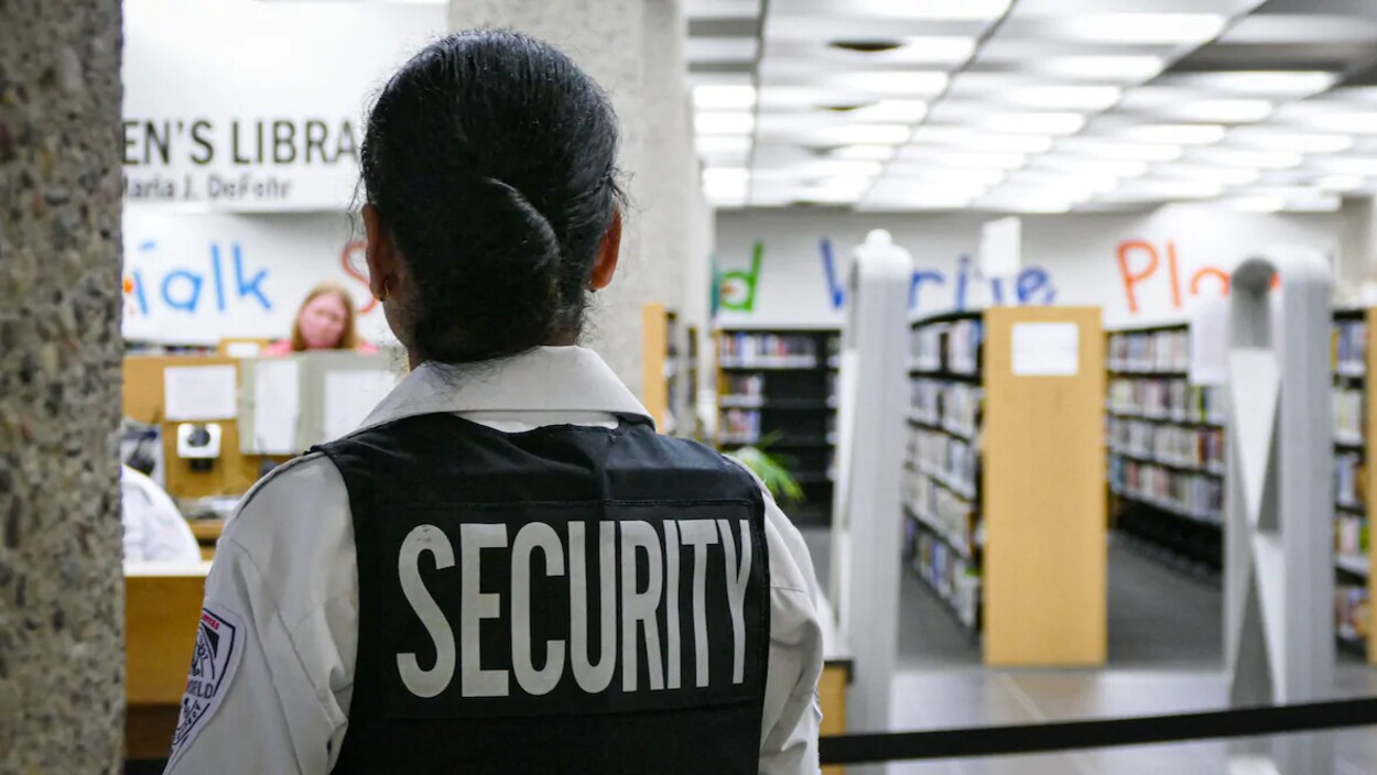 Un gardien de sécurité de dos dans la bibliothèque du Millénaire.