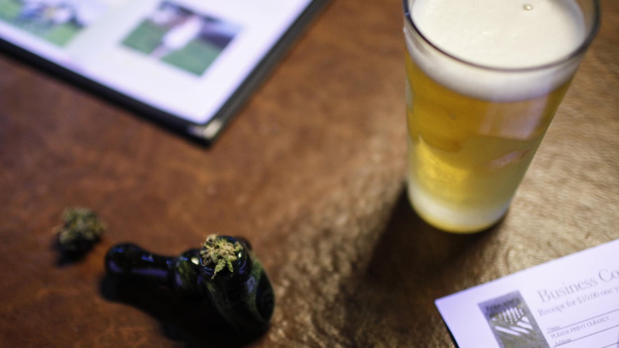 Une pipe à marijuana à côté d'une bière.