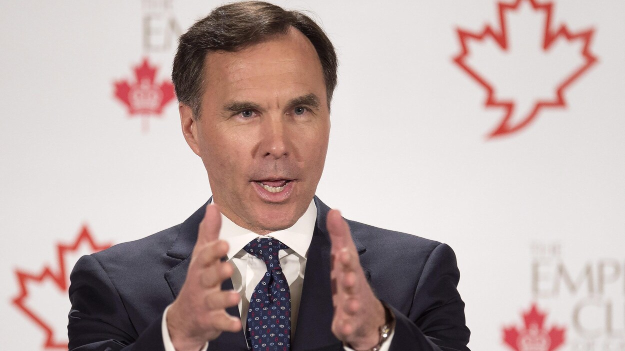 Le ministre des Finances Bill Morneau, devant un fond blanc avec des feuilles d'érables, à Toronto Le ministre des Finances Bill Morneau, devant un fond blanc avec des feuilles d'érables, à Toronto