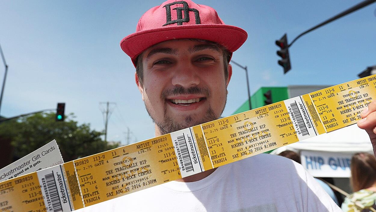 Un homme montre ses billets du dernier concert de Tragically Hip, à Kingston. Un homme montre ses billets du dernier concert de Tragically Hip, à Kingston.