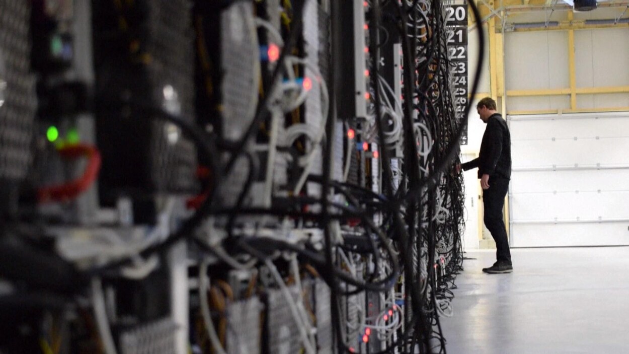 Un homme vérifie les fils d'un serveur d'une ferme de bitcoins.