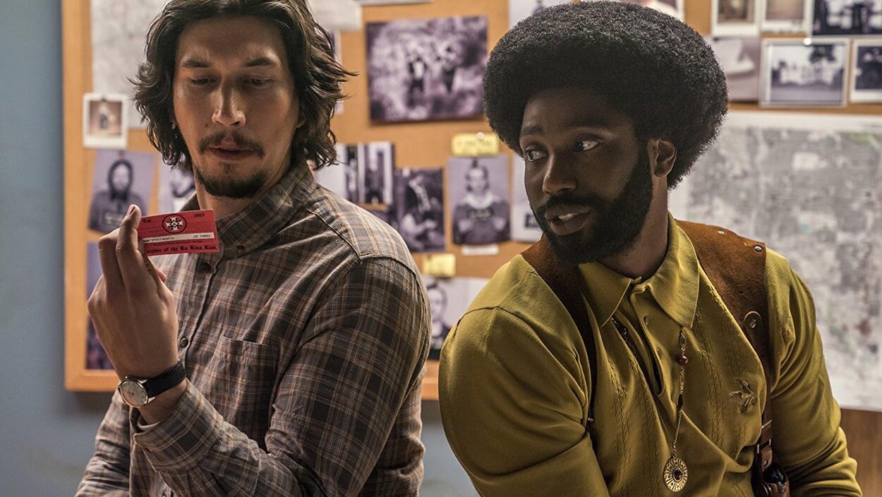 Adam Driver et John David Washington regardent une carte de visite dans une scène du film «Opération infiltration<». Adam Driver et John David Washington regardent une carte de visite dans une scène du film «Opération infiltration<».