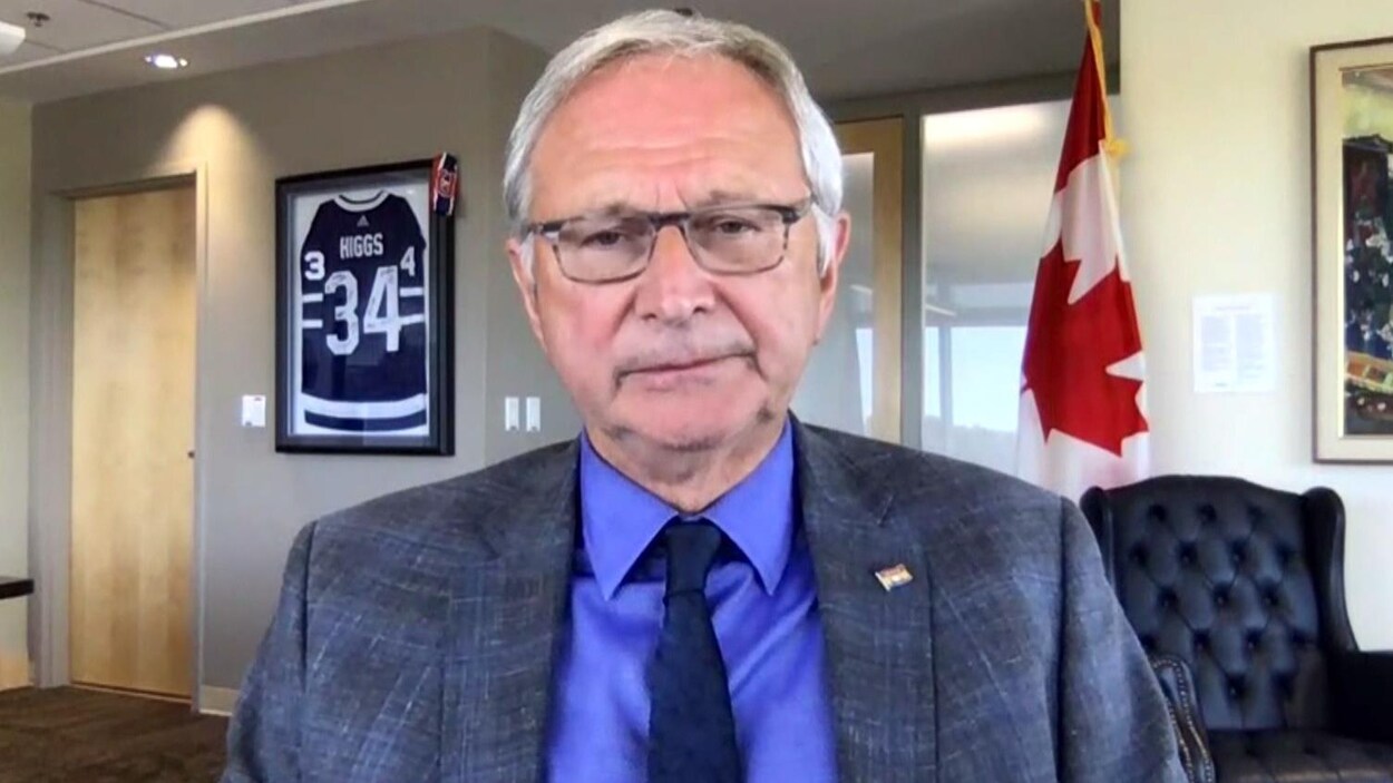 Le premier ministre du Nouveau-Brunswick, Blaine Higgs, dans son bureau qui regarde une caméra.
