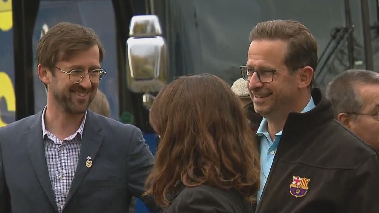 Au milieu de quelques personnes, près de l'autobus du Bloc québécois, Yves-François Blanchet et Louis Gagnon sourient.