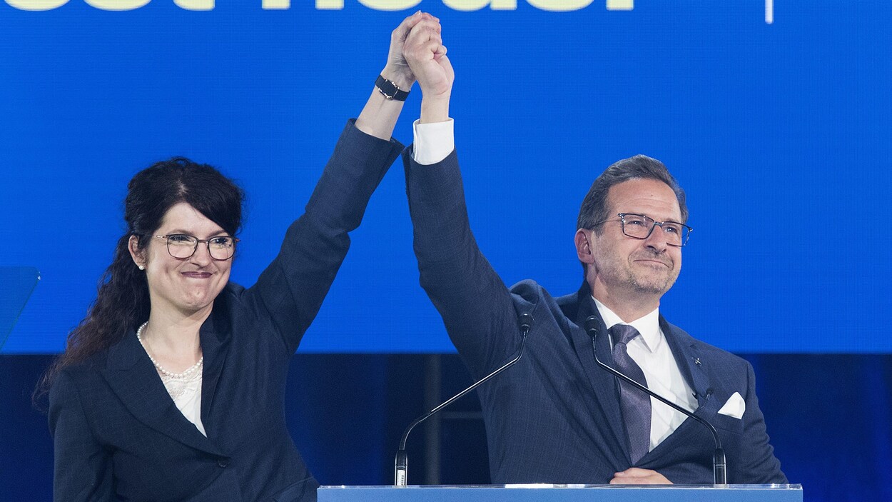 Yves-François Blanchet et sa conjointe les mains en l'air sur la scène devant les partisans du Bloc québécois.