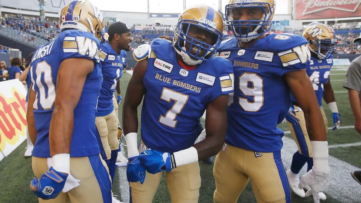 Trois joueurs de football célèbrent leur victoire dans un stade
