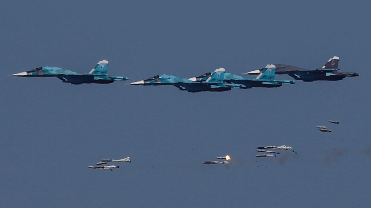 Des avions Sukhoi Su-34 russes larguent des bombes lors de manoeuvres aériennes.