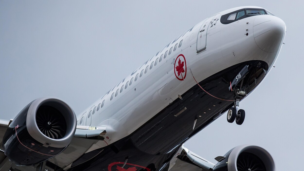 Un avion Boeing 737 Max de la compagnie Air Canada, pris en photo en contre-plongée alors qu'il décolle du tarmac.