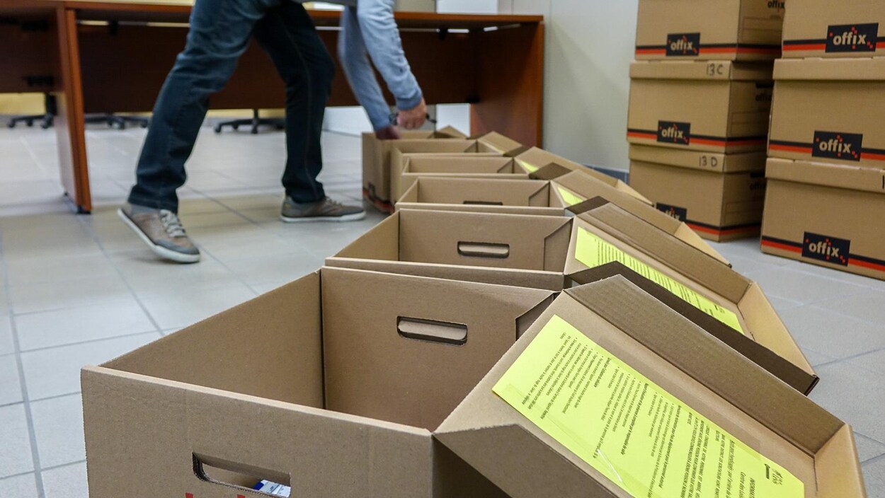 Un travailleur d'élection avec des boîtes d'équipement pour les bureaux de scrutin. Un travailleur d'élection avec des boîtes d'équipement pour les bureaux de scrutin.