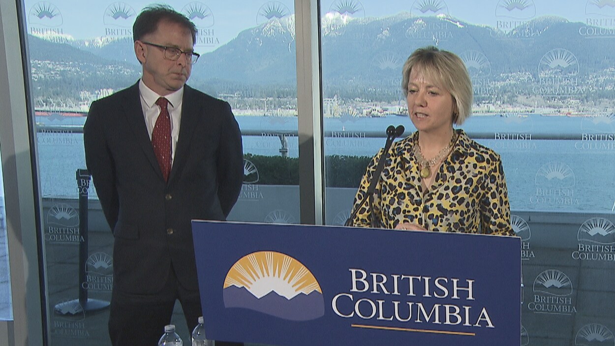 Le ministre de la Santé, Adrian Dix, et la médecin hygiéniste en chef, Bonnie Henry debout devant deux micros en point de presse le 14 mars 2020.