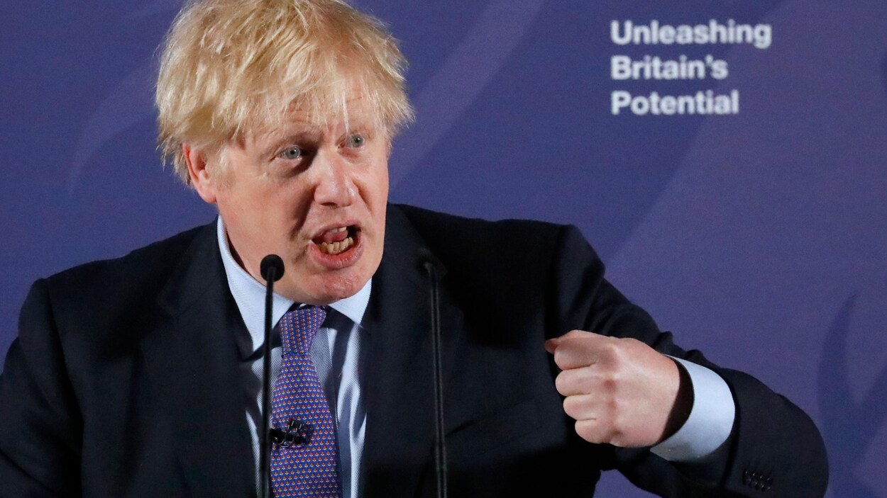 Boris Johnson parle dans des micros sur une scène.