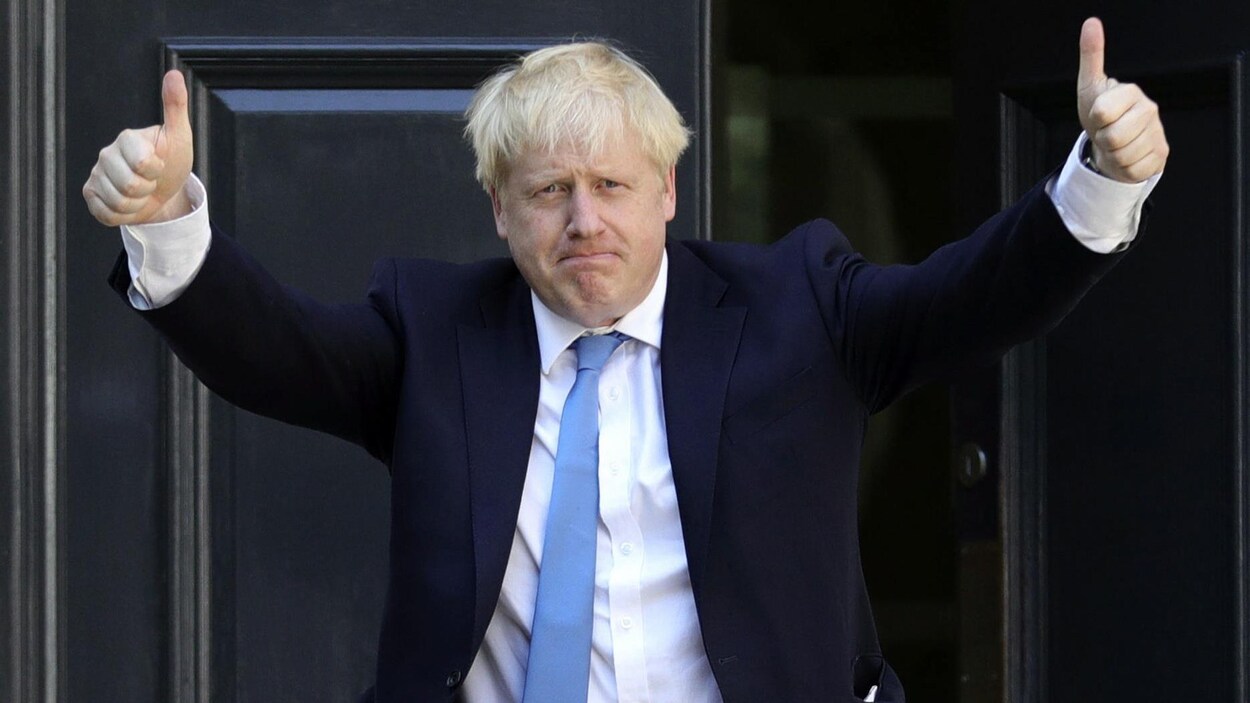 Boris Johnson, les deux pouces en l'air en signe de victoire.