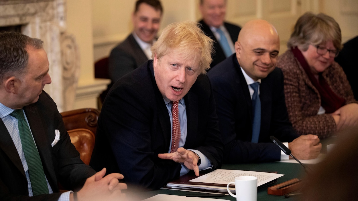 Boris Johnson, assis à une table, parle. Des ministres l'écoutent.