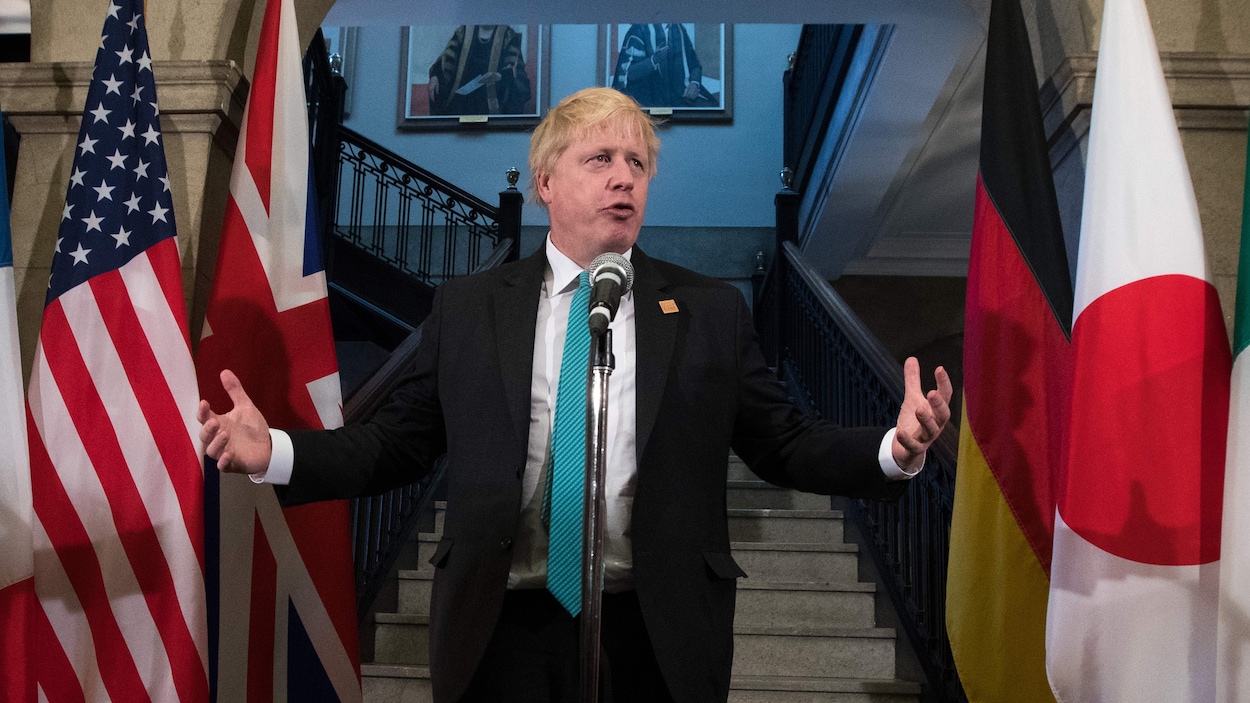 Boris Johnson, debout devant un micro.