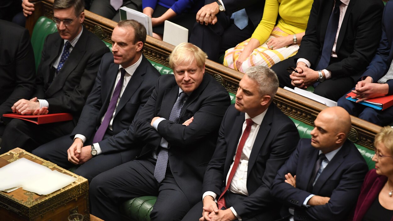 Boris Johnson est assis, bras croisés.