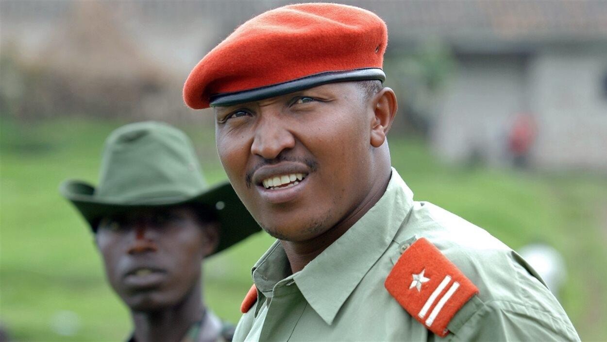 Un officier congolais se tient aux côtés d'un combattant.