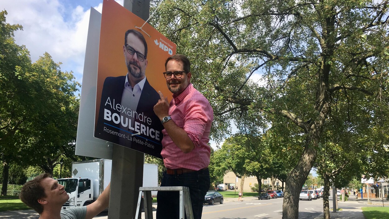 Alexandre Boulerice dans un escabeau en train d'installer une des ses pancartes électorales.