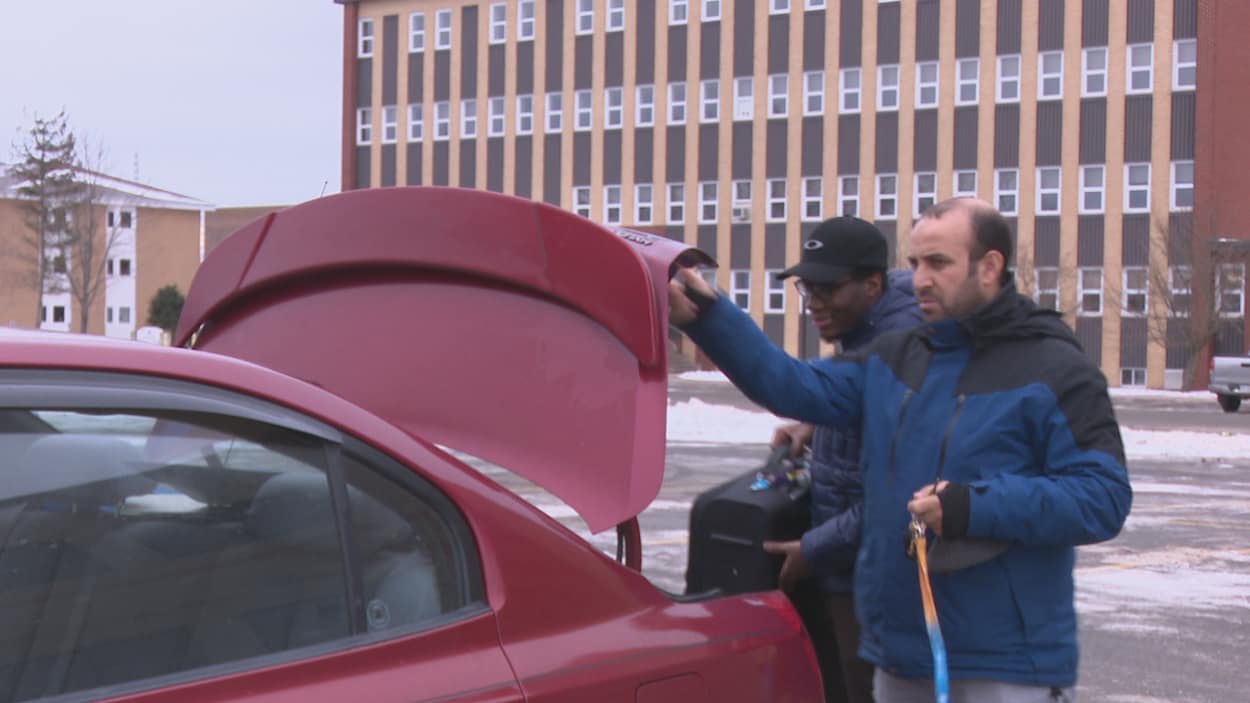 Amine Bouriche ouvre le coffre de sa voiture pour qu'un étudiant y dépose sa valise. Amine Bouriche ouvre le coffre de sa voiture pour qu'un étudiant y dépose sa valise.