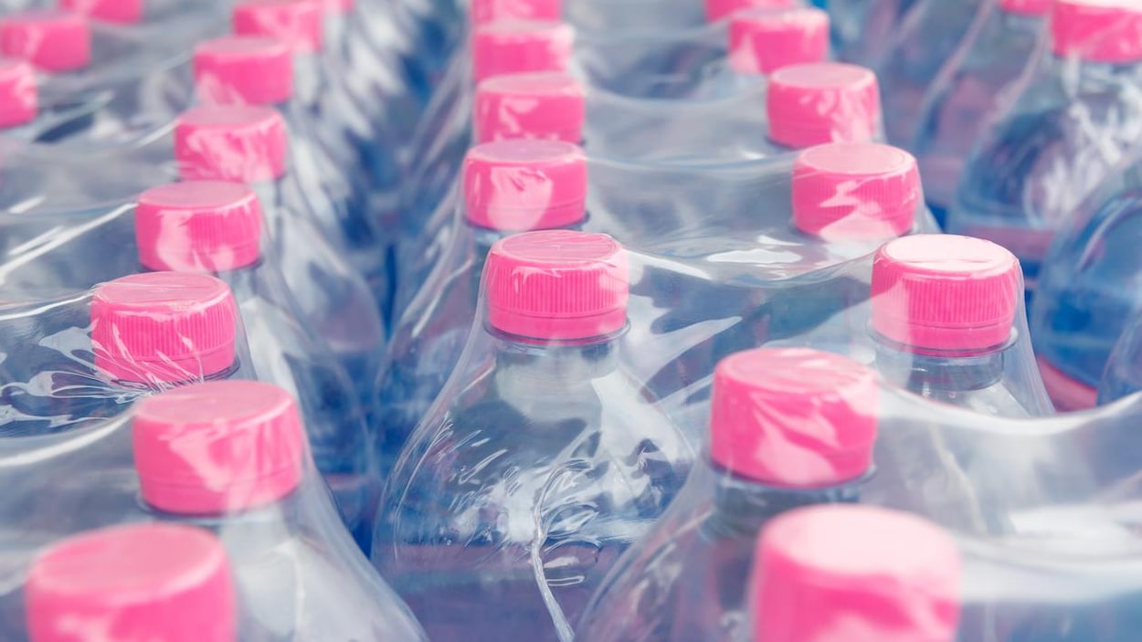 Des bouteilles d'eau en plastique emballées dans du plastique.