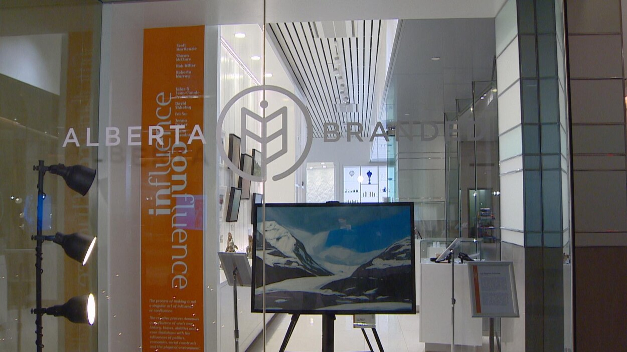 Devanture vitrée de la boutique-galerie Alberta Branded derrière laquelle se trouve une toile illustrant des montagnes enneigées.