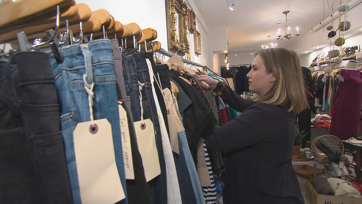Pascale Landry trie les vêtements dans sa boutique.
