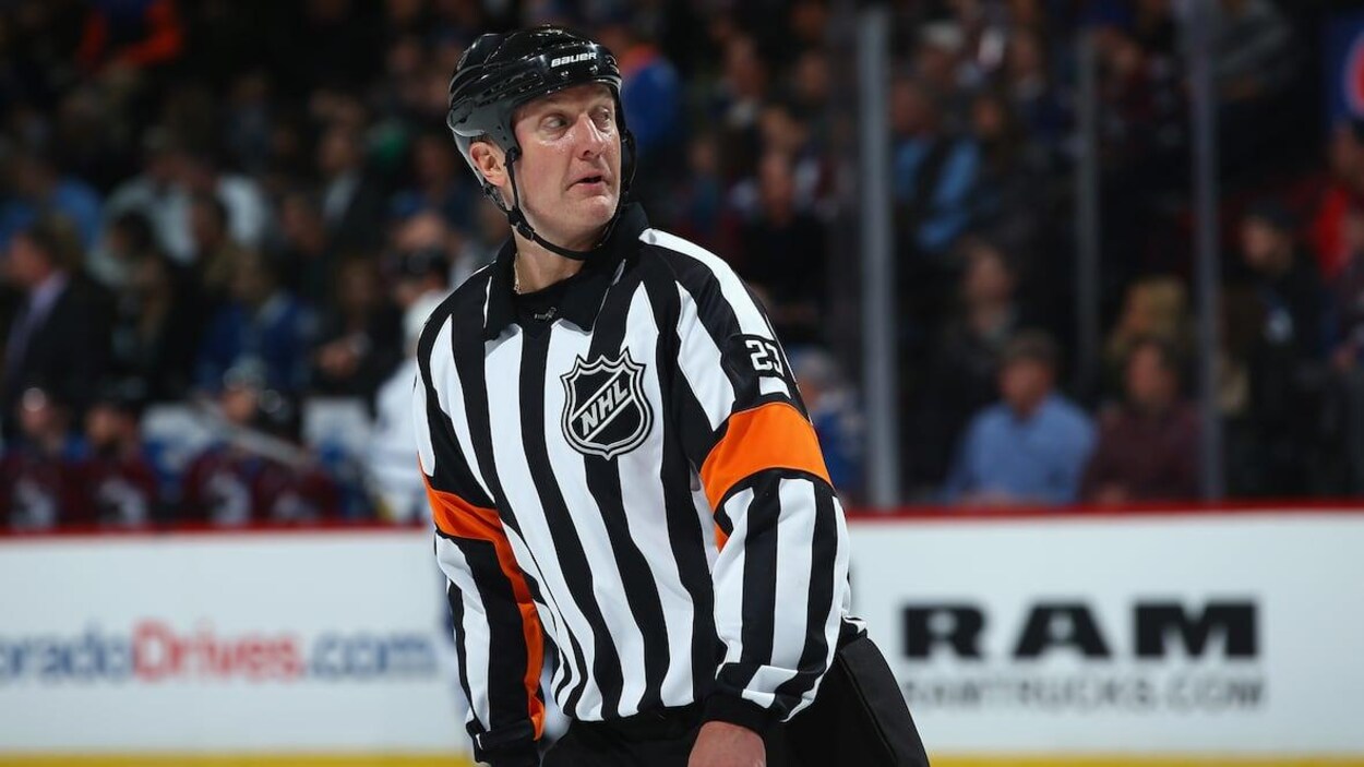 L'arbitre Brad Watson lors de son 1000e match à Denver en 2014 avance sur la glace en tournant la tête vers sa gauche.