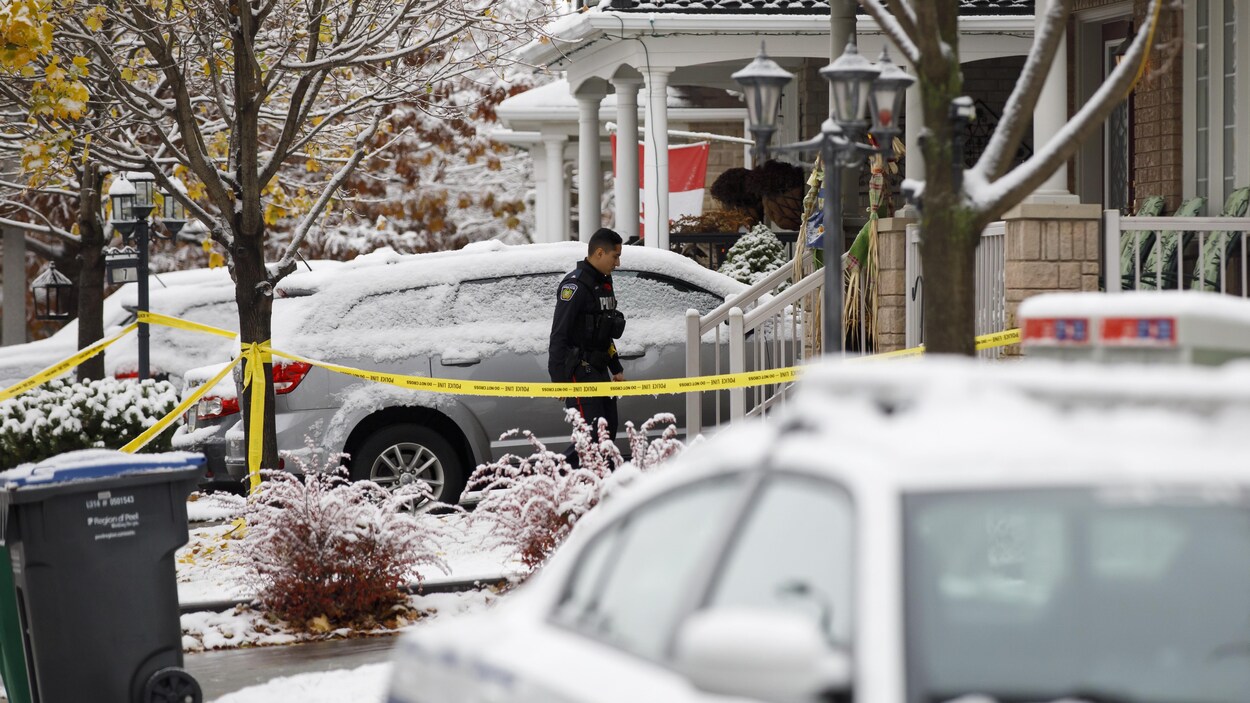 Un policier devant la maison où les corps des deux victimes ont été trouvés.