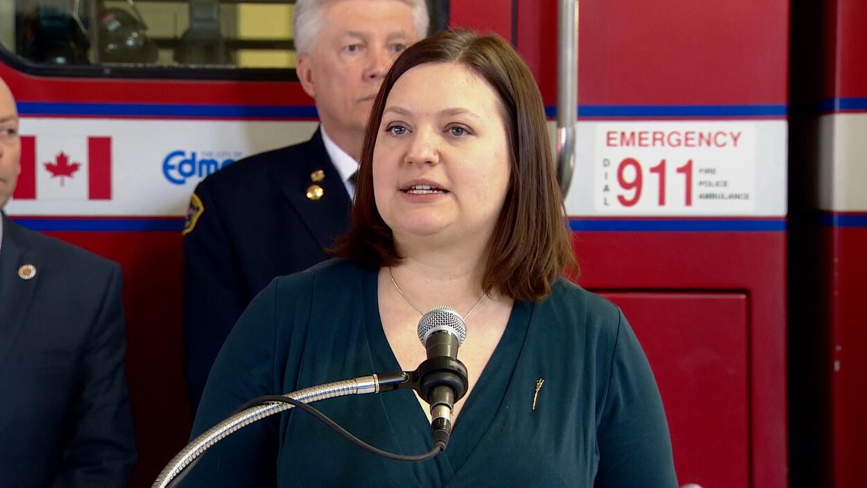 Brandy Payne, la ministre adjointe de la Santé de l'Alberta devant un camion de pompiers Brandy Payne, la ministre adjointe de la Santé de l'Alberta devant un camion de pompiers