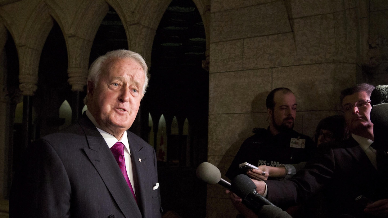 L'ancien premier ministre Brian Mulroney répond aux questions des journalistes à la sortie du cabinet libéral jeudi.