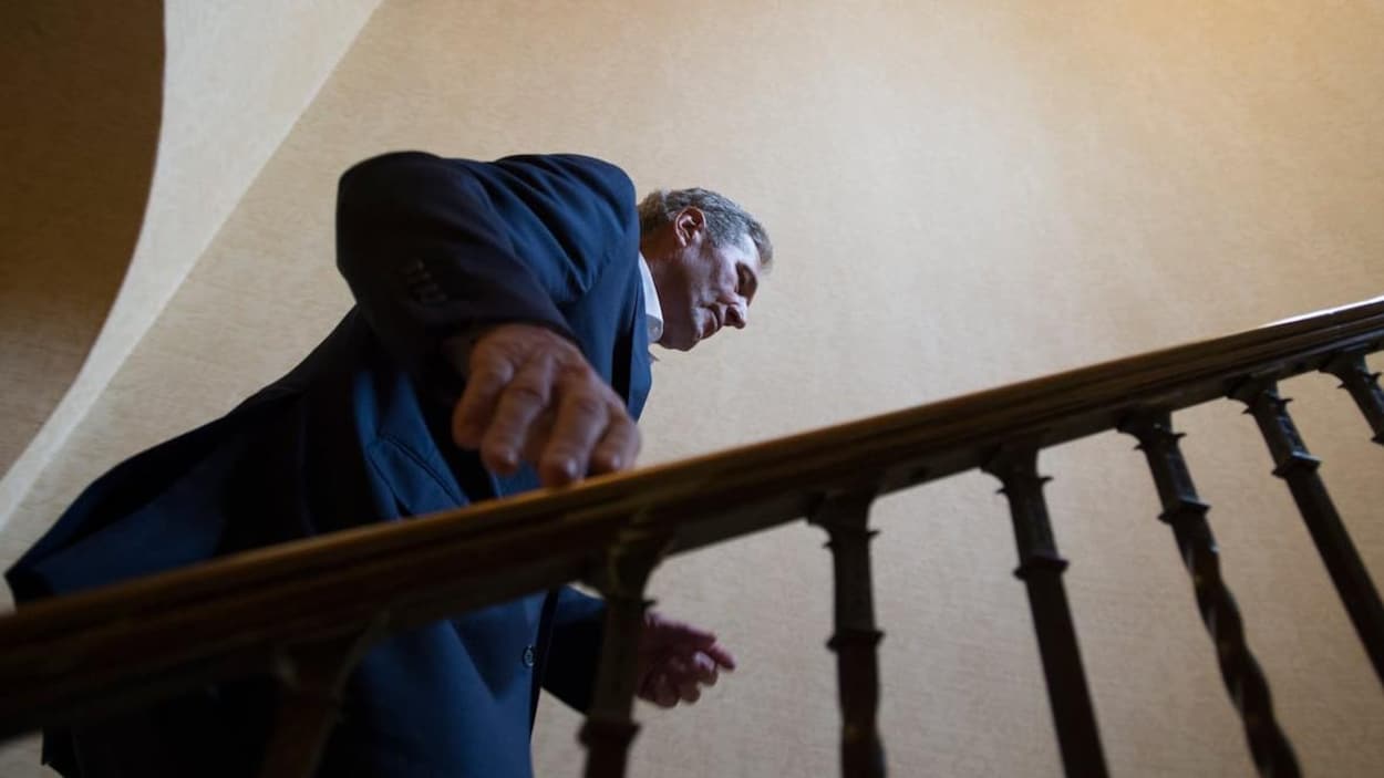 Un homme montant les marches d'un escalier, vu en contre-plongée.