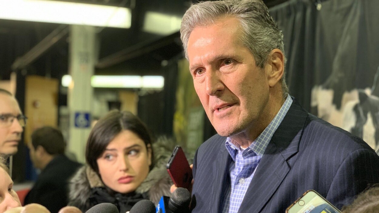 Brian Pallister en conférence de presse, interrogé par des journalistes.