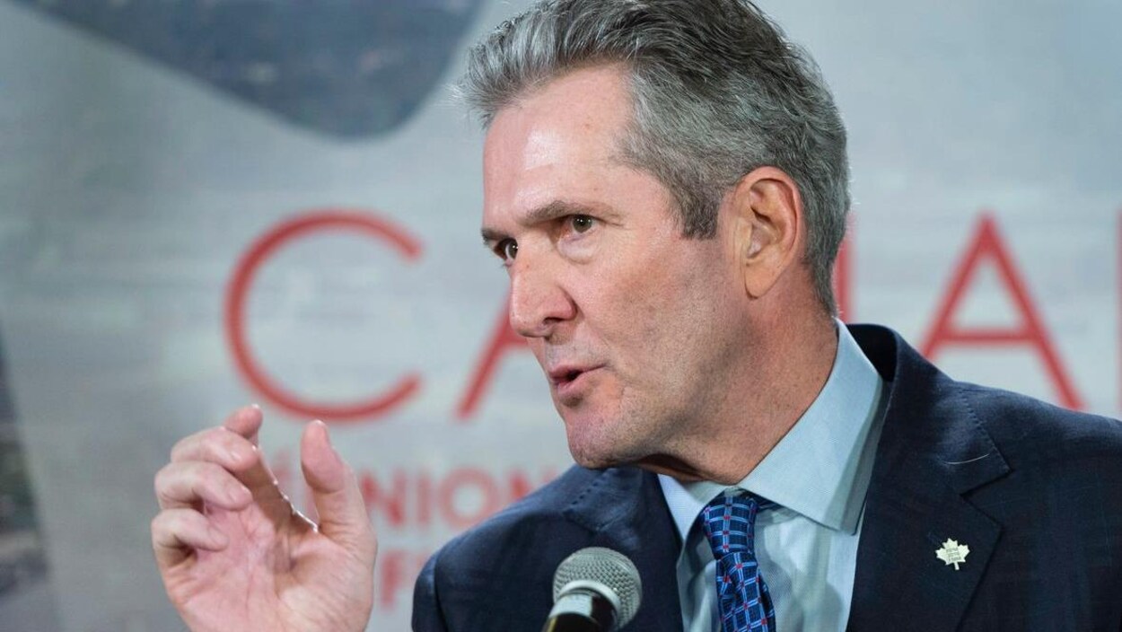 Le premier ministre du Manitoba, Brian Pallister, porte un costume-cravate et a la tête tournée vers la gauche lors d'un discours.