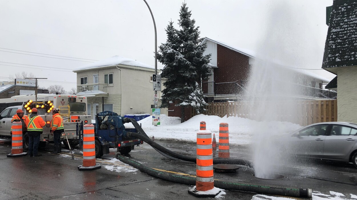 L'eau jaillit d'une bouche d'égouts.
