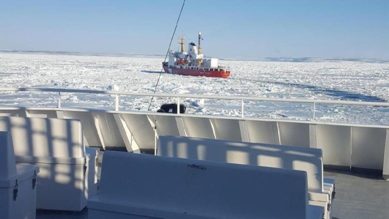 Un brise-glace dans un océan gelé photographié du pont d'un bateau.