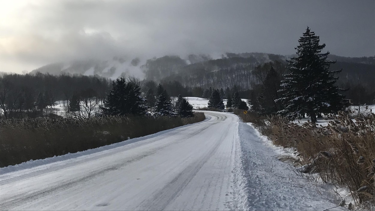 Une route enneigée. Ski Bromont au loin.